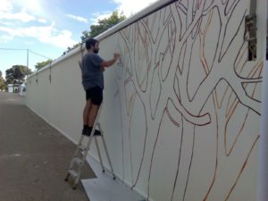Pintando árboles en la paredes del Pabellón Infantil